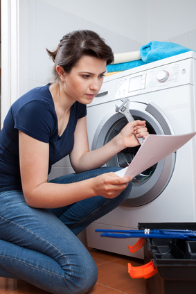 Woman reading manual instruction and trying to repair washing machine